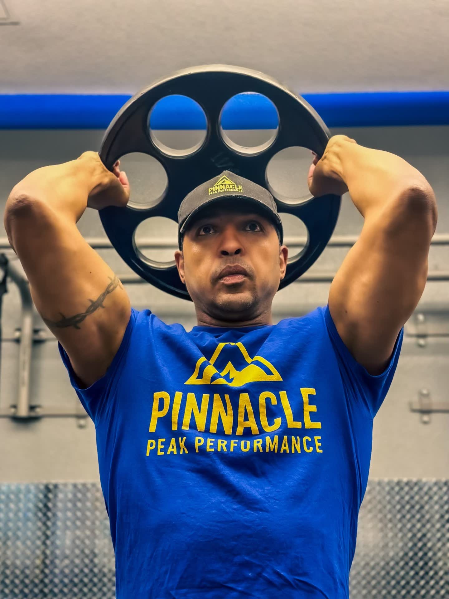 John Hall pressing a weight plate overhead